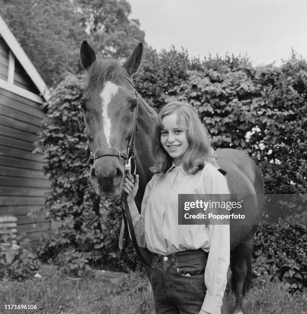 English actress Susan George, who appears in the television soap opera Weavers Green, holding the bridle of a horse in June 1966.