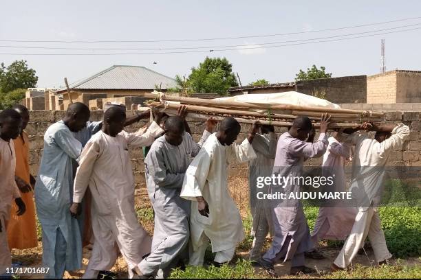 Mourners carry a body of one of the victims of the Boko Haram attack on September 28, 2019 in Gajiram, Borno State. Escalating violence in northwest...