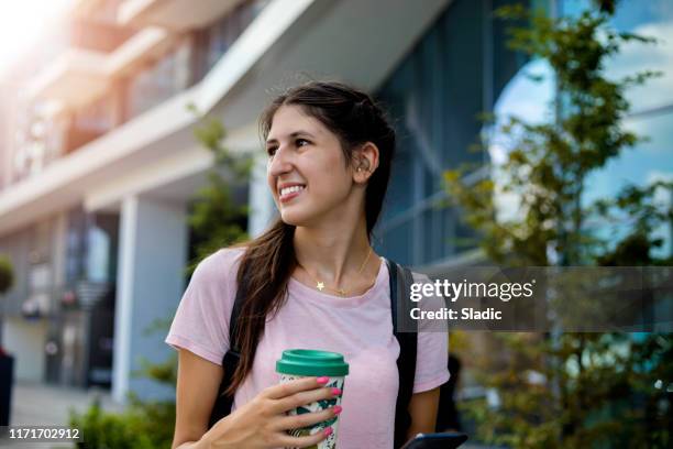 teenage girl with hearing aid walking on city street - hearing aids stock pictures, royalty-free photos & images