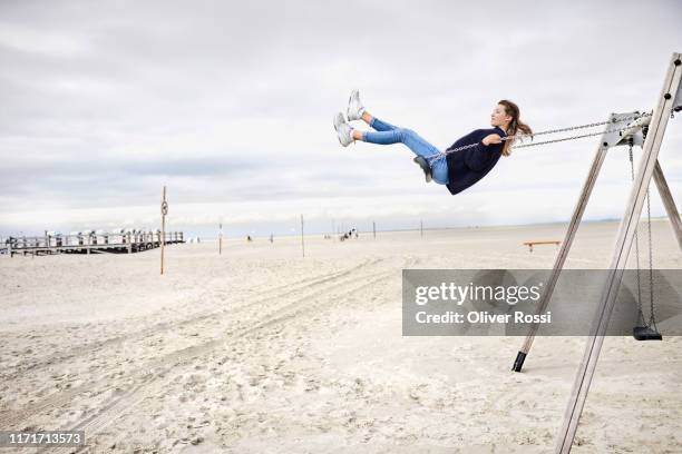 girl on a swing on the beach - effortless stock pictures, royalty-free photos & images