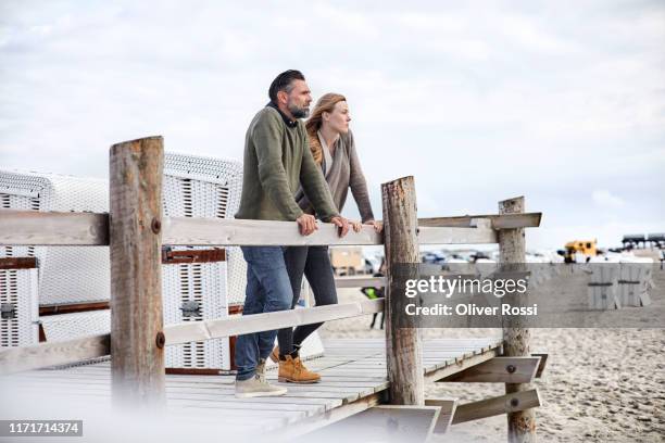 father and adult daughter standing on boardwalk on the beach - hooded beach chair stock pictures, royalty-free photos & images