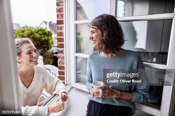 two happy women talking through the window - female with friend in coffee stock pictures, royalty-free photos & images