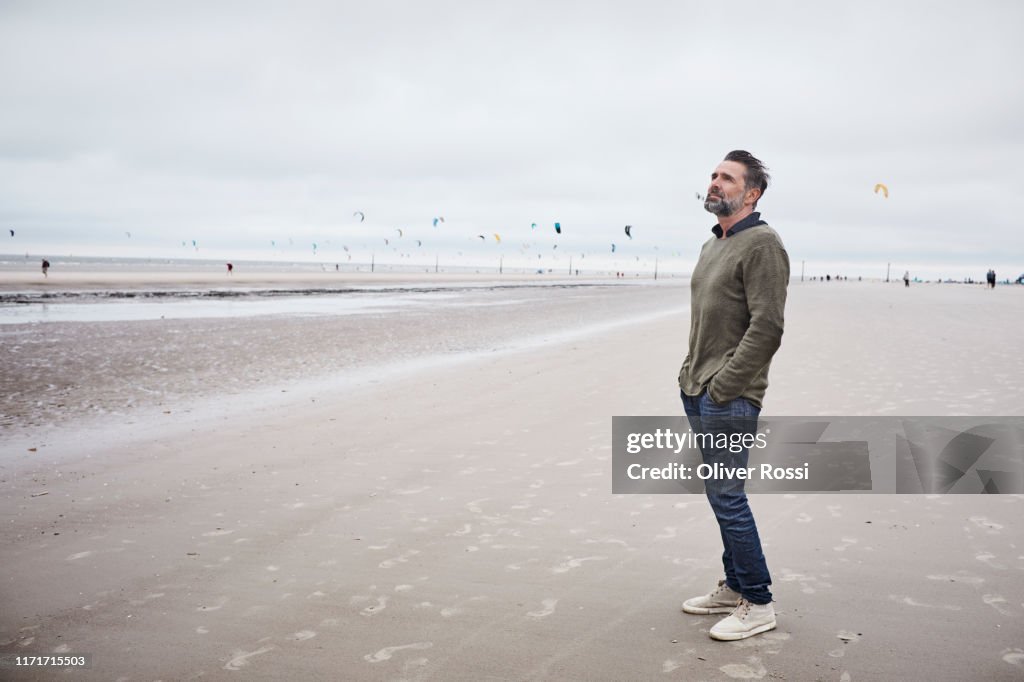 Pensive man standing on the beach