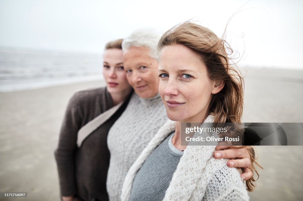 Portrait of grandmother, mother and daughter on the beach