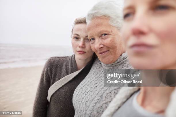 portrait of grandmother, mother and daughter on the beach - multi generation family portrait stock pictures, royalty-free photos & images