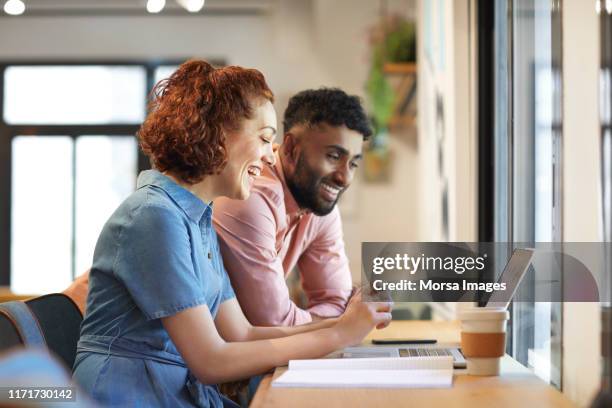 multi-ethnic colleagues discussing over laptop - happy businessman working at his office with laptop stock pictures, royalty-free photos & images