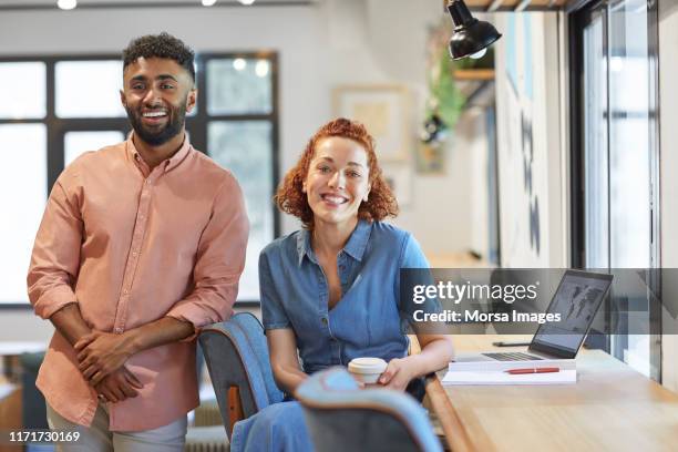 smiling young multi-ethnic coworkers in office - woman business desk front laptop office fotografías e imágenes de stock