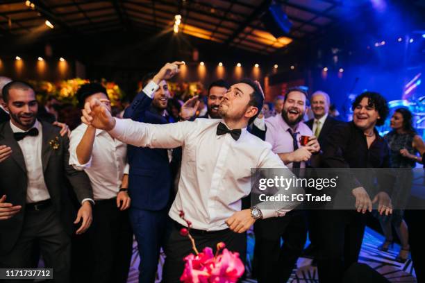 bruidegom en bruiloftsgasten lachen tijdens het feest - wedding reception stockfoto's en -beelden