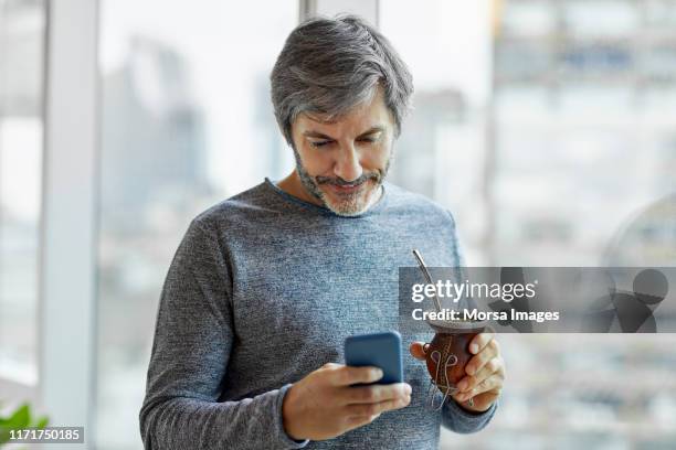 businessman using phone while having yerba mate - mate argentina stock pictures, royalty-free photos & images