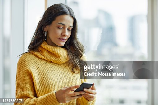 Mid adult executive using smart phone at office Mid adult executive using smart phone at office
