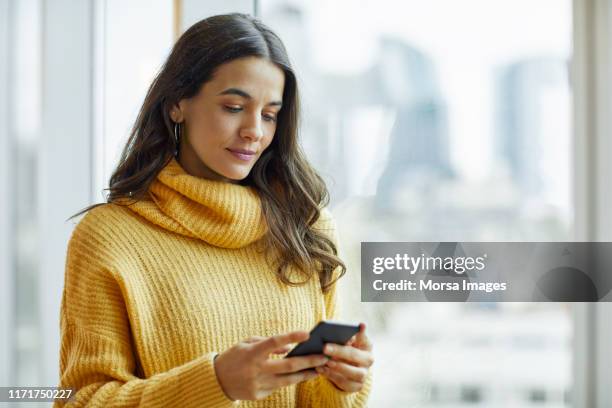 mid adult executive using smart phone at office - business text messaging stock pictures, royalty-free photos & images