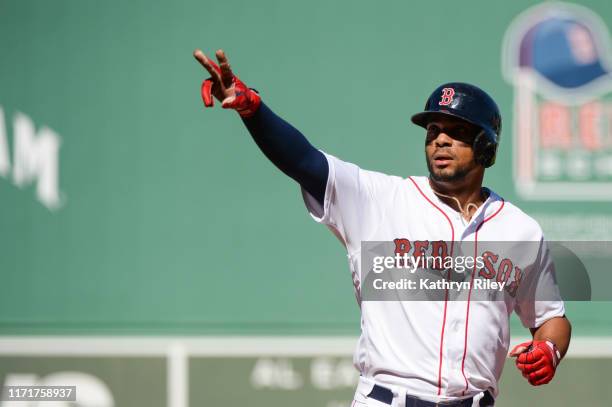 Xander Bogarts of the Boston Red Sox reacts after hitting a two-run home run in the first inning against the Baltimore Orioles at Fenway Park on...