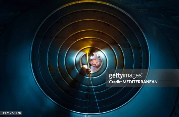 cellar worker cleaning wine tank with water - examining wine stock pictures, royalty-free photos & images