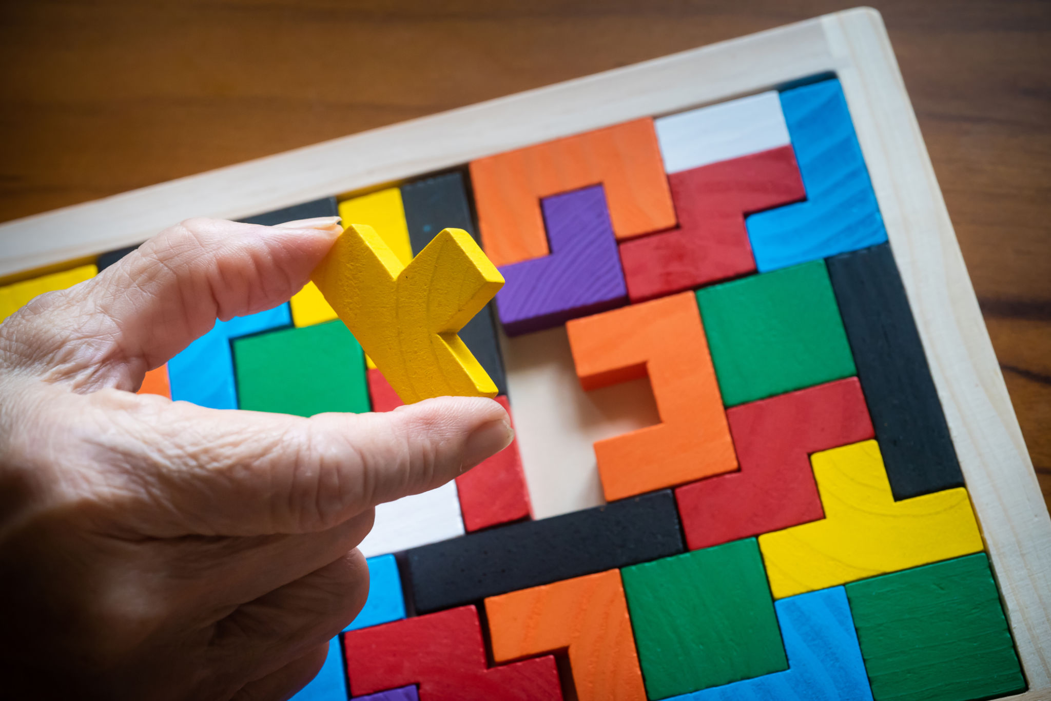 Senior adult playing wodden brick game Senior adult playing wodden brick game