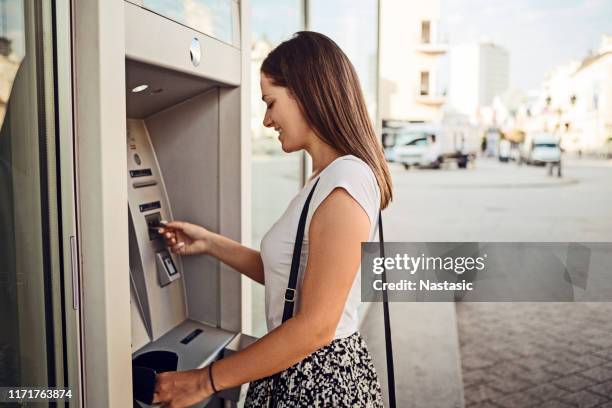 woman withdrawing money at the outdoor atm - atm cash stock pictures, royalty-free photos & images