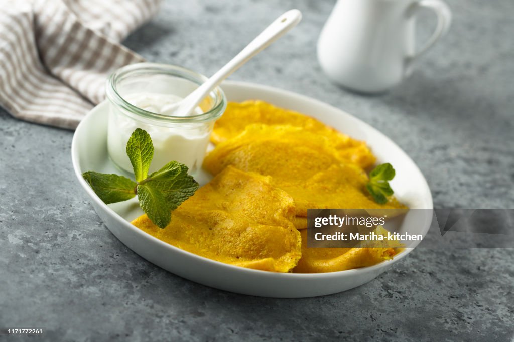 Yellow pancakes with cream