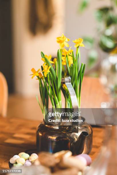 a table decorated with candy eggs, soda and blooming daffodils for easter - easter flowers stock pictures, royalty-free photos & images