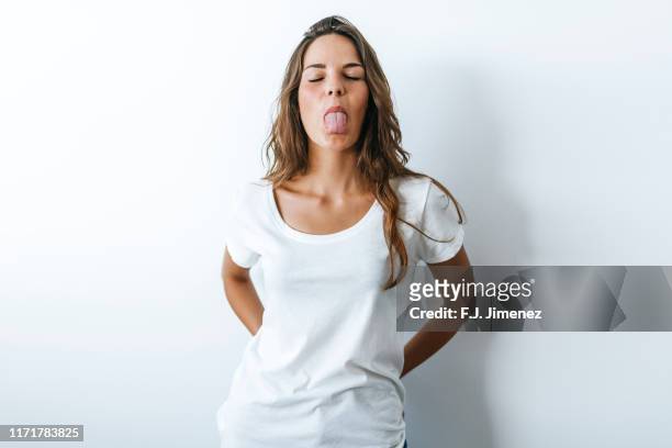portrait of woman sticking out her tongue - sticking out tongue stock-fotos und bilder