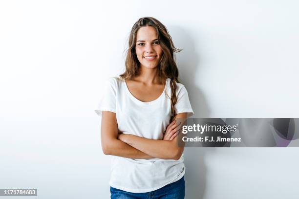 portrait of woman with crossed arms - young women white background stock pictures, royalty-free photos & images