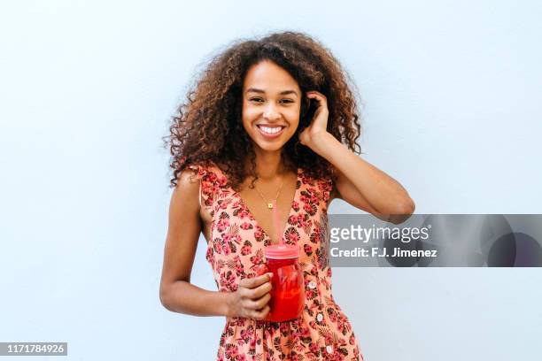 portrait of smiling woman with drink - frau sommerlich studioaufnahme stock-fotos und bilder
