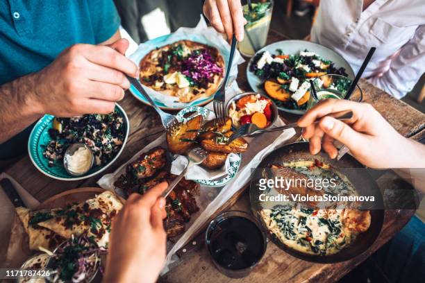 enjoying lunch with friends - sharing stock pictures, royalty-free photos & images