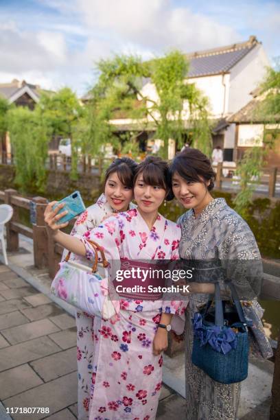 mother and daughters in yukata taking selfie picture in traditional japanese village - offspring culture tourism festival stock pictures, royalty-free photos & images