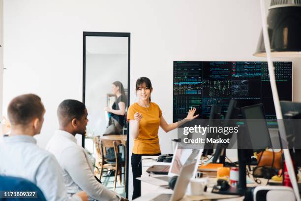 female hacker interacting with colleagues while giving presentation in office - business casual dress code stock pictures, royalty-free photos & images