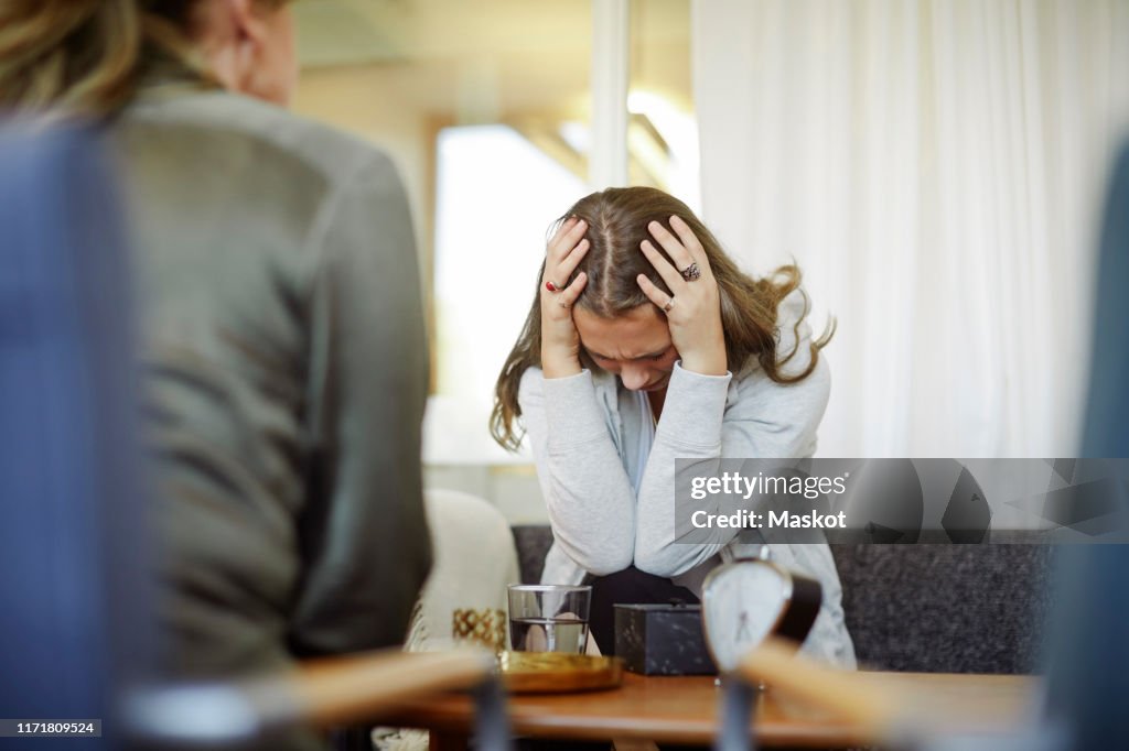 Displeased female patient discussing with therapist during session