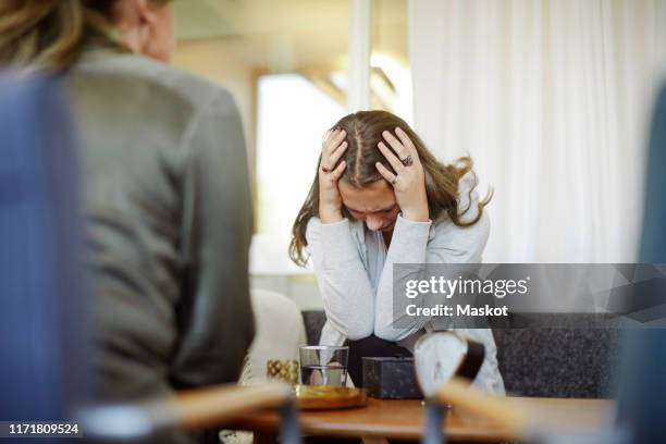 displeased female patient discussing with therapist during session - crying woman stock pictures, royalty-free photos & images