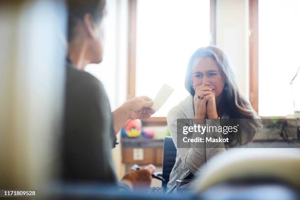 therapist giving prescription to crying patient during session - psychische belastung am arbeitsplatz stock-fotos und bilder