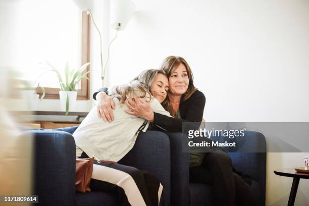 mother and daughter embracing while sitting at wellness center - alternative therapy stock pictures, royalty-free photos & images