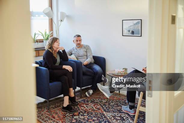 man and woman talking to counselor while sitting at workshop - alternative therapy stock pictures, royalty-free photos & images