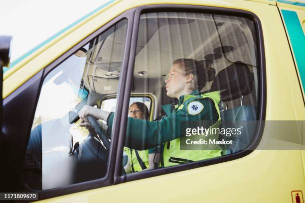 female paramedics traveling in ambulance - paramedic photos et images de collection