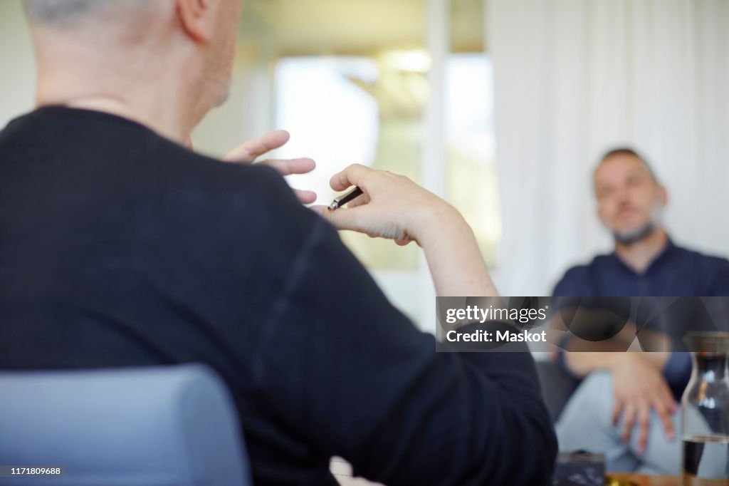 Midsection of doctor explaining patient during psychotherapy session