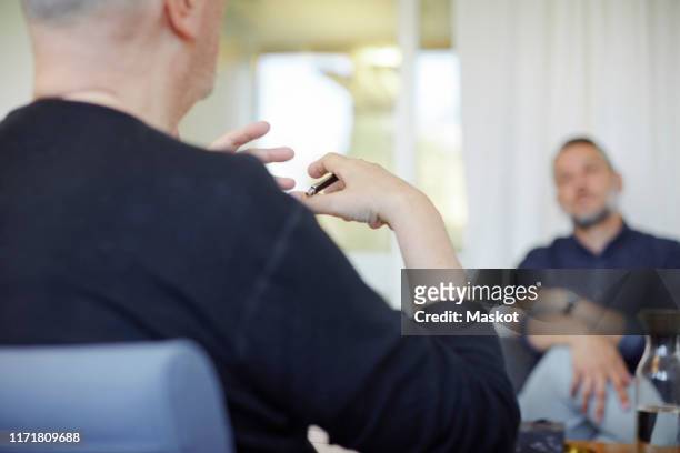 midsection of doctor explaining patient during psychotherapy session - alternative therapy stock pictures, royalty-free photos & images