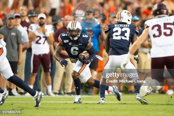 Wide receiver Ja'Varrius Johnson of the Auburn Tigers looks to run the ball by safety Landon Guidry of the Mississippi State Bulldogs during the...