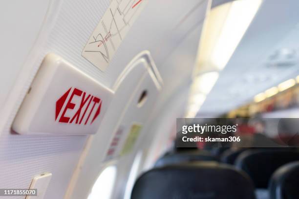 close up shot sign in airplane near emergency exit doors - vehicle door stock pictures, royalty-free photos & images