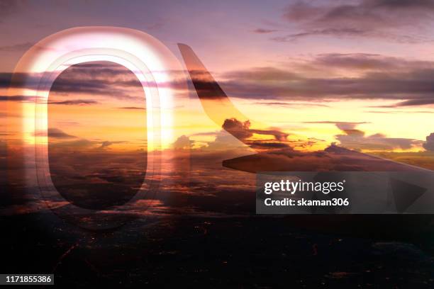 aerial view twilight overlay with window seat and wing of airplane - bon voyage stock pictures, royalty-free photos & images