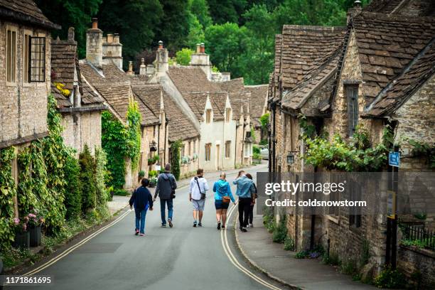 vila inglesa idílica tradicional do campo com casas de campo cosy e estrada estreita no castelo combe, reino unido - cotswolds - fotografias e filmes do acervo