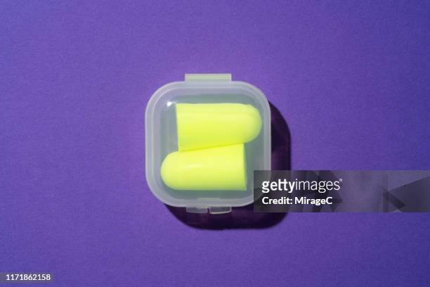 vibrant yellow ear plugs in plastic box - ear plug stock pictures, royalty-free photos & images