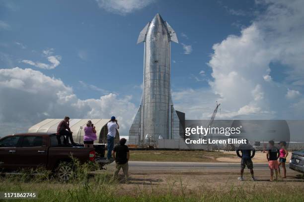 Space enthusiasts look at a prototype of SpaceX's Starship spacecraft at the company's Texas launch facility on September 28, 2019 in Boca Chica near...