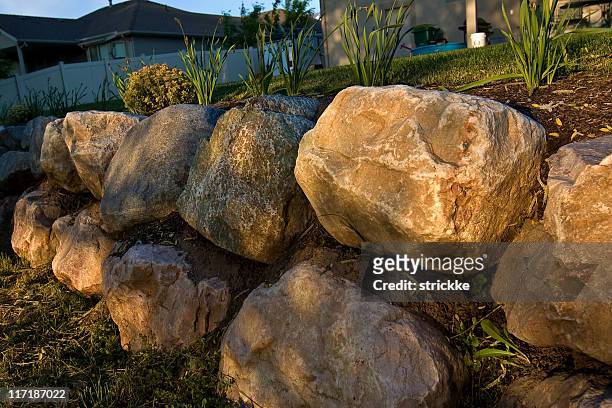 filtra golden luz del sol iluminates rock muro de contención - roca grande fotografías e imágenes de stock