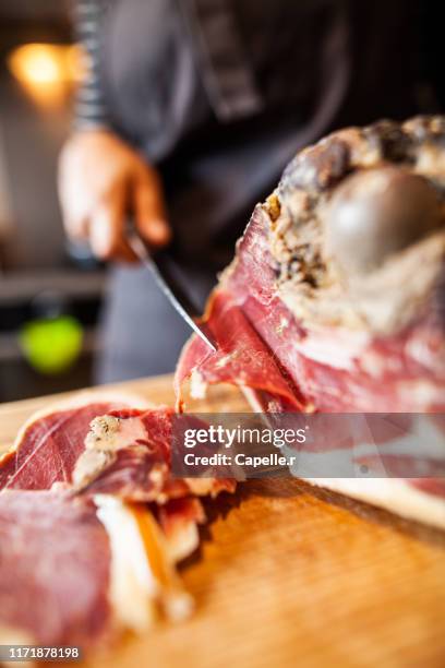 cuisine - découpe d'une pièce de jambon cru - jambon cru stock-fotos und bilder