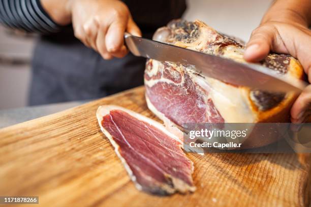 cuisine - découpe d'une pièce de jambon cru - cured ham stock pictures, royalty-free photos & images