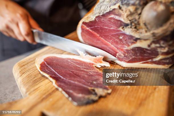 cuisine - découpe d'une pièce de jambon cru - jambon cru stock-fotos und bilder