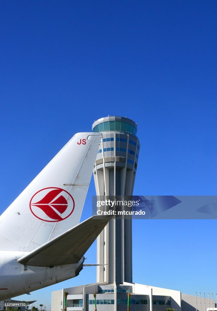 Algiers Airport, Houari Bouemedienne International Airport, control tower operated by ENNA and passing Air Algérie aircraft, Algiers, Algeria