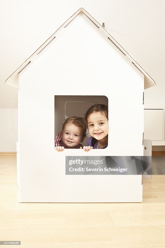 Boy and girl in cardgoard house