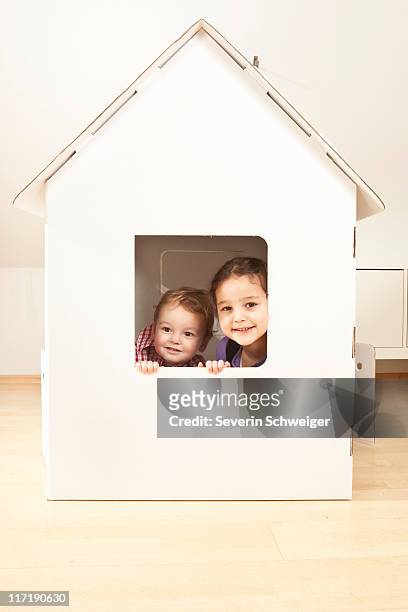 boy and girl in cardgoard house - casa de brinquedo imagens e fotografias de stock