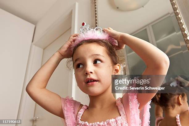 girl putting crown on her head - princess stock pictures, royalty-free photos & images