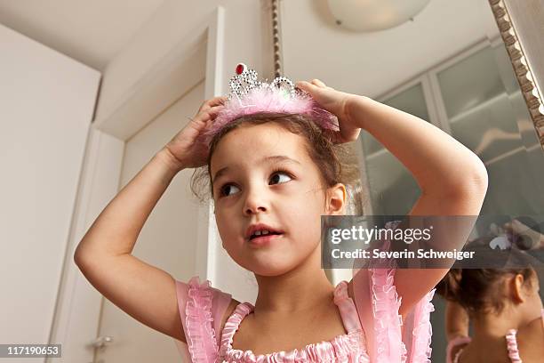 girl putting crown on her head - 公主 個照片及圖片檔